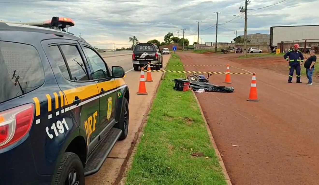 Viatura da PRF ao lado da motocicleta, a qual a adolescente pilotava e morreu após colidir com caminhão