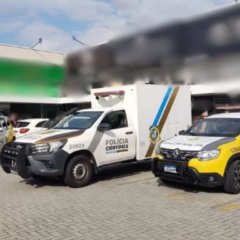 Viaturas da Polícia Militar e carro da Polícia Científica no local em que duas pessoas morreram baleadas durante assalto