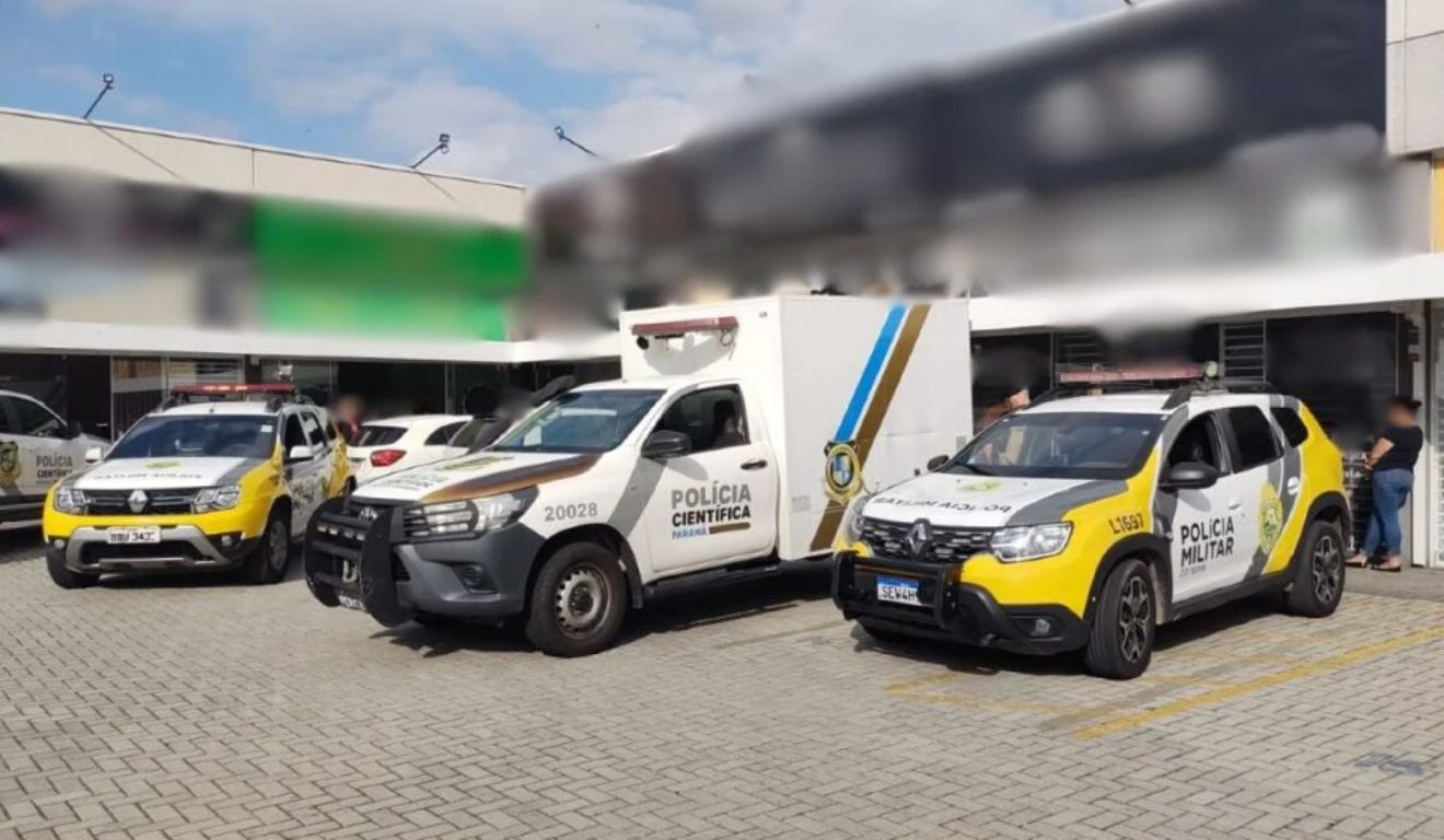 Viaturas da Polícia Militar e carro da Polícia Científica no local em que duas pessoas morreram baleadas durante assalto