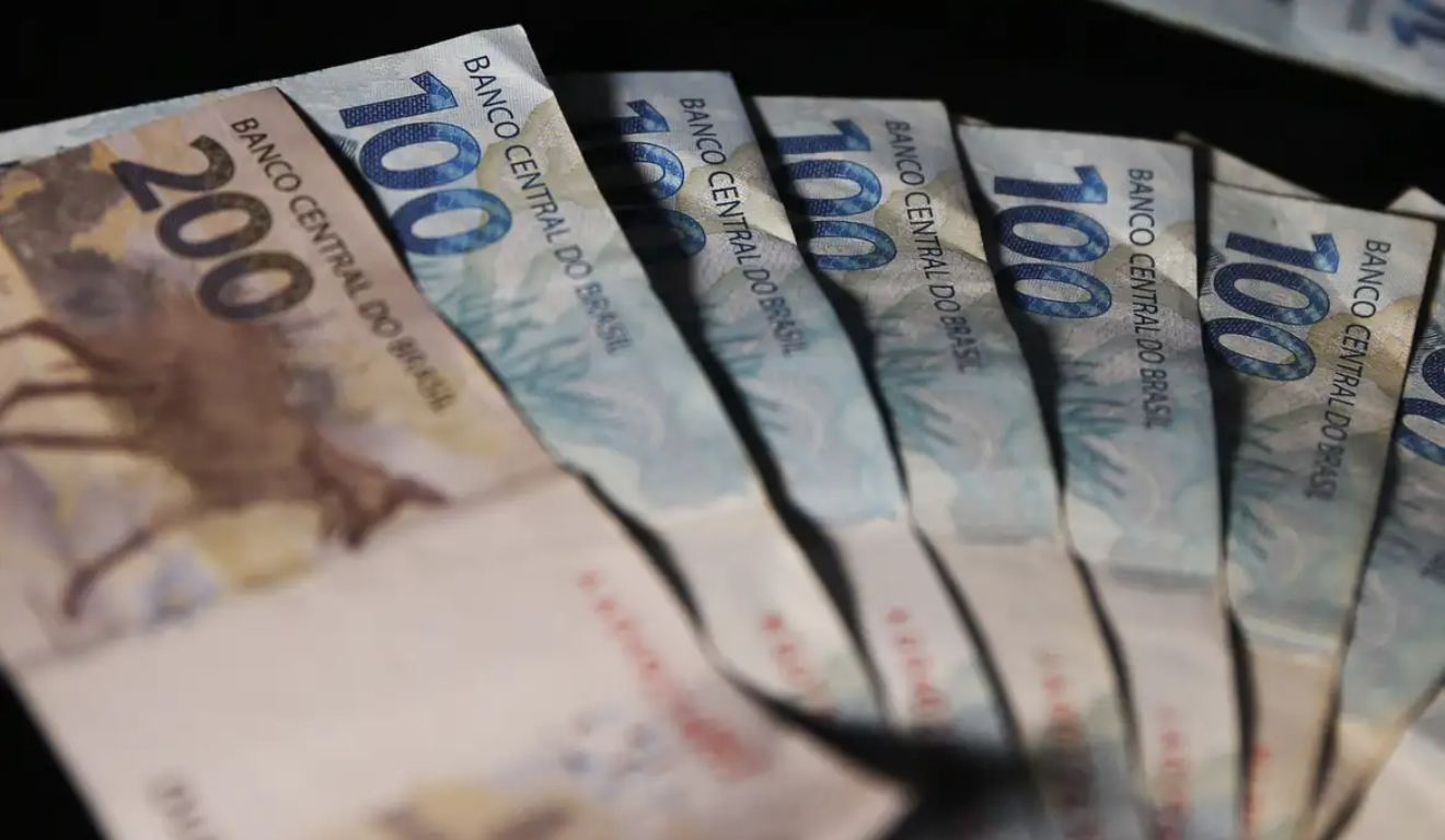 Notas de R$ 100 e uma de R$ 200; imagem ilustrativa representando o abono salarial que pode ser sacado pelos trabalhadores brasileiros.