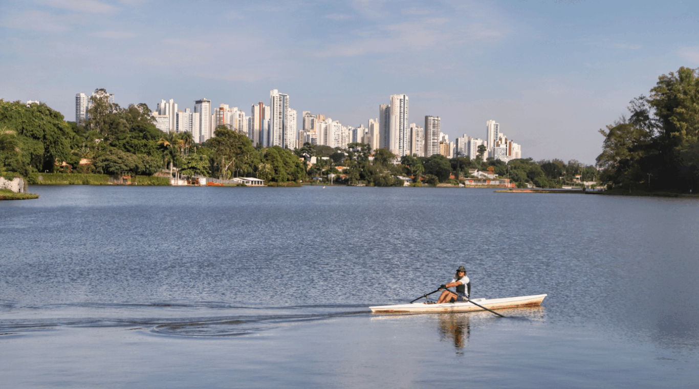 pessoa praticando canoagem no lago de londrina, com a cidade ao fundo