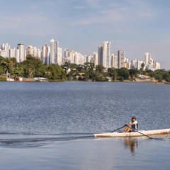 pessoa praticando canoagem no lago de londrina, com a cidade ao fundo