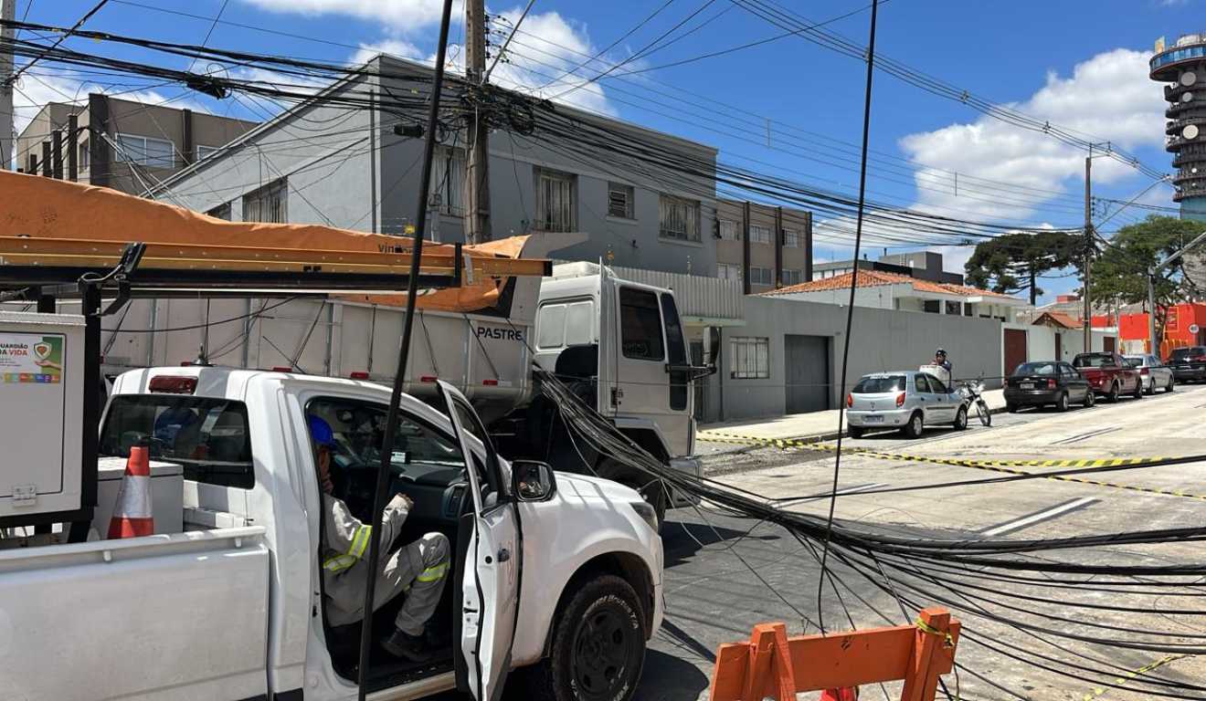 foto de caminhão enroscado em fio na Rua Jacarezinho, no cruzamento com a Avenida Manoel Ribas, nas mercês