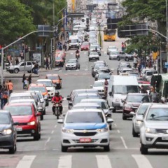 Trânsito de veículos fluindo em rua de Curitiba