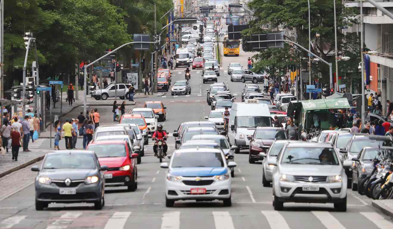 Trânsito de veículos fluindo em rua de Curitiba