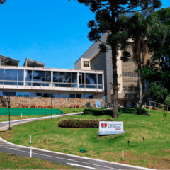 fachada da celepar, com o gramado, pr&eacute;dio ao fundo e c&eacute;u azul