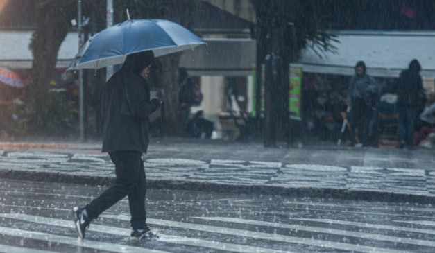 pessoa andando na chuva para ilustrar o fim do ciclone no paraná