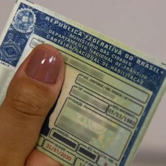 Mulher segura exemplar da carteira nacional de habilitação: novas regras da CNH entram em vigor nesta semana
