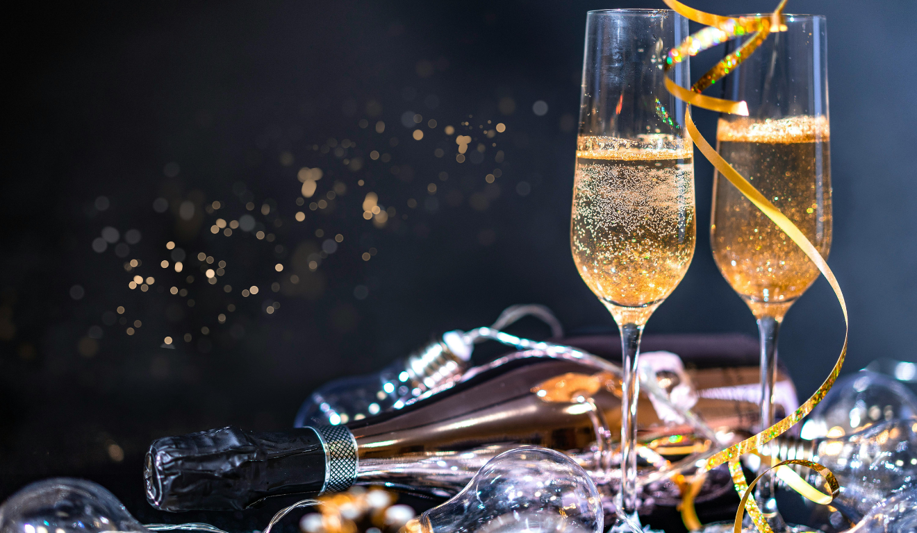 Vemos duas taças de champagne, simbolizando as celebrações de Ano Novo; saiba em que dia da semana cai o Réveillon 2025.
