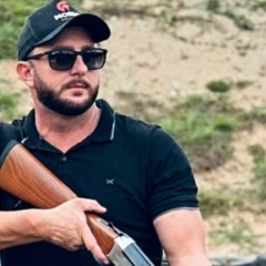 Walter Berger com uma arma na mão durante competição de tiro