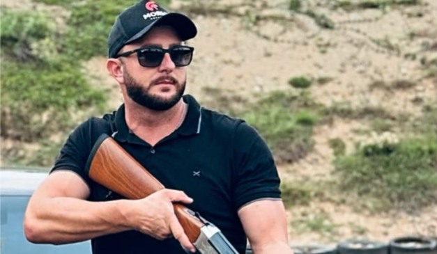 Walter Berger com uma arma na mão durante competição de tiro