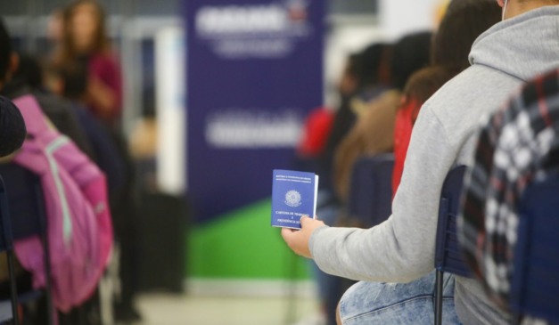 Homem segura a carteira de trabalho enquanto aguarda atendimento em uma agência de emprego do Paraná