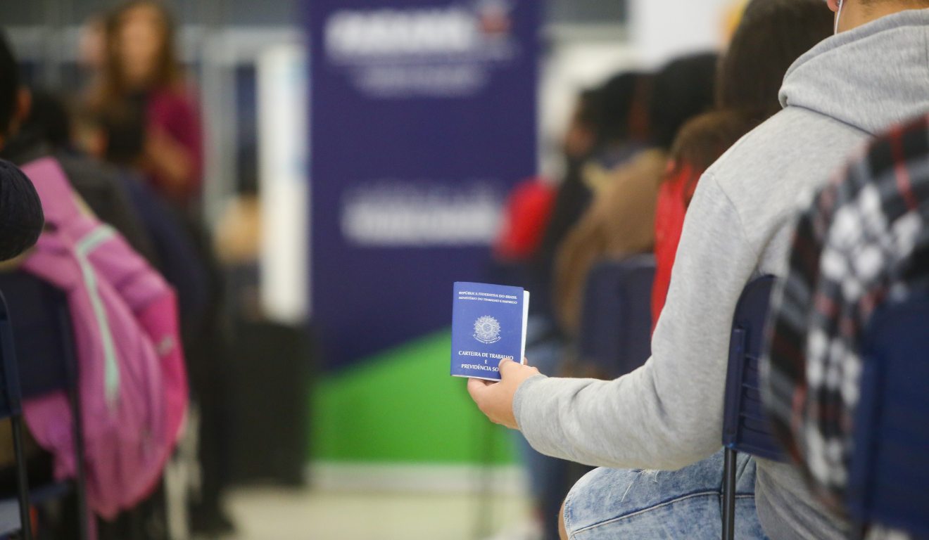 Homem segura a carteira de trabalho enquanto aguarda atendimento em uma agência de emprego do Paraná