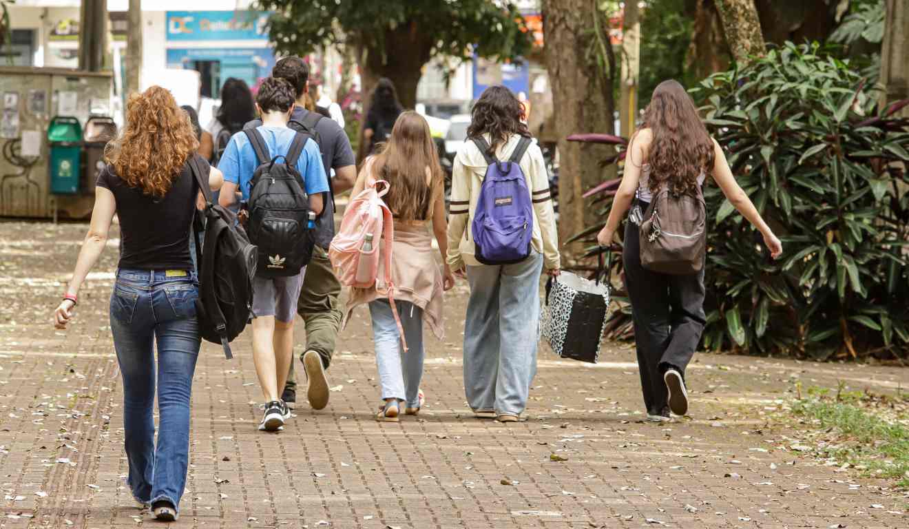 Populares com mochila nas costas a caminho do ensino