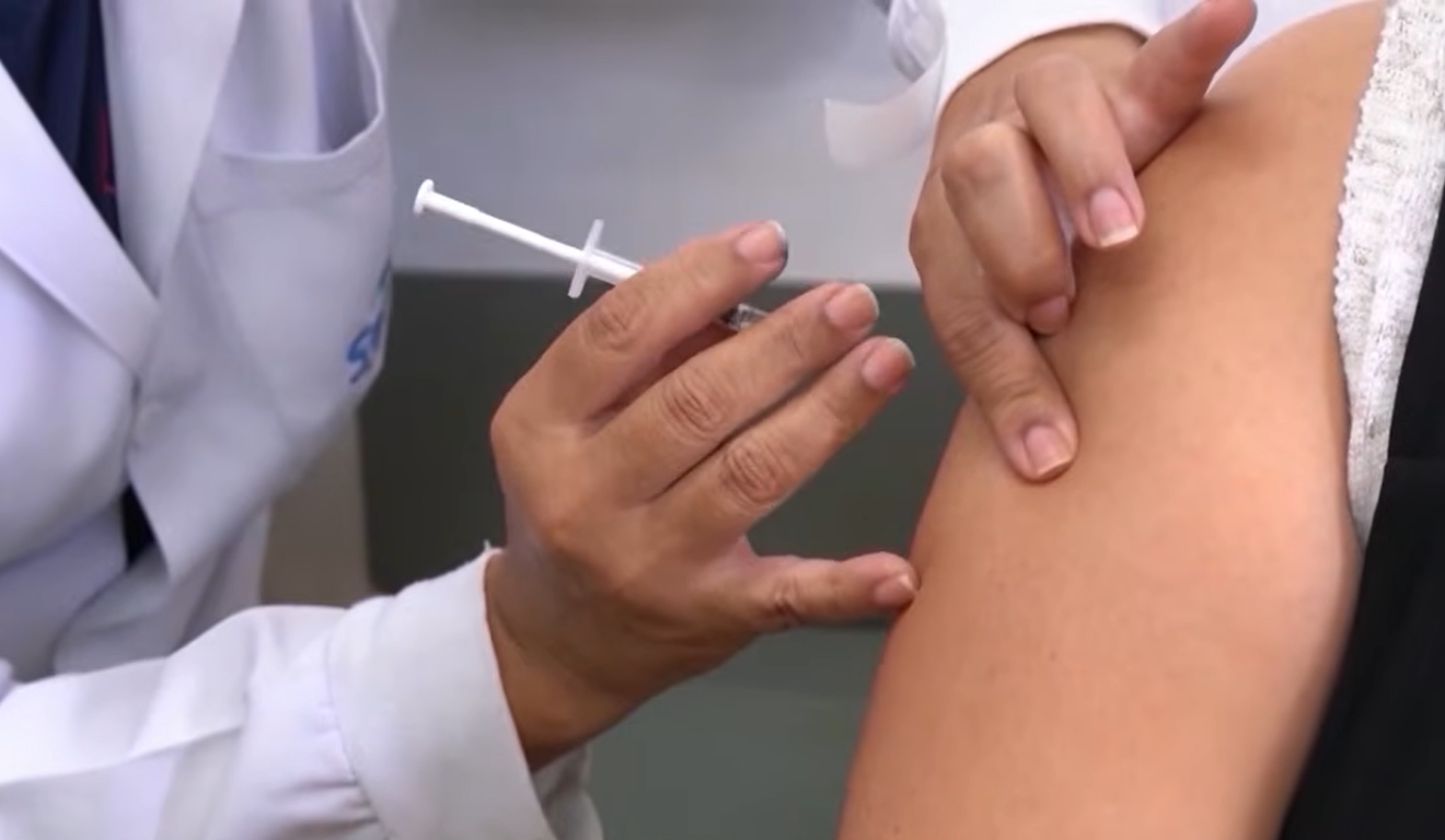 Profissional da saúde aplicando uma vacina em uma paciente; OMS reforça que a vacinação é fundamental contra a Gripe K.