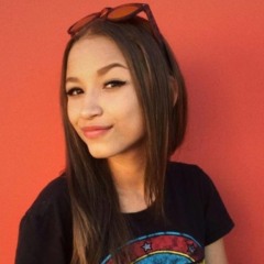 Isis Victoria Mizerski sorrindo em foto, com um óculos na cabeça