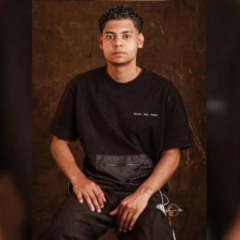 Jovem que desapareceu em Ponta Grossa sentado, com fundo marrom