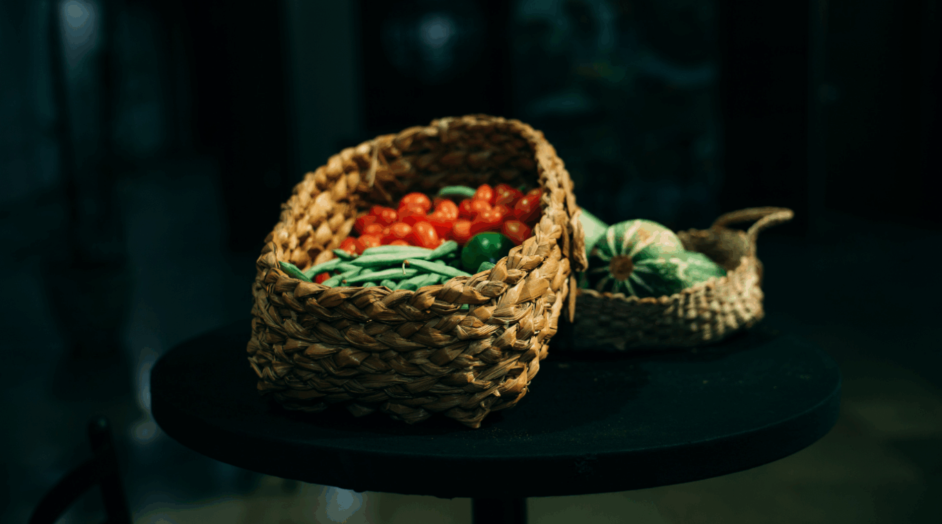 verduras e legumes em cestas de palha, com fundo preto.