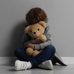 criança segurando urso de pelúcia