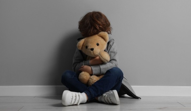 criança segurando urso de pelúcia