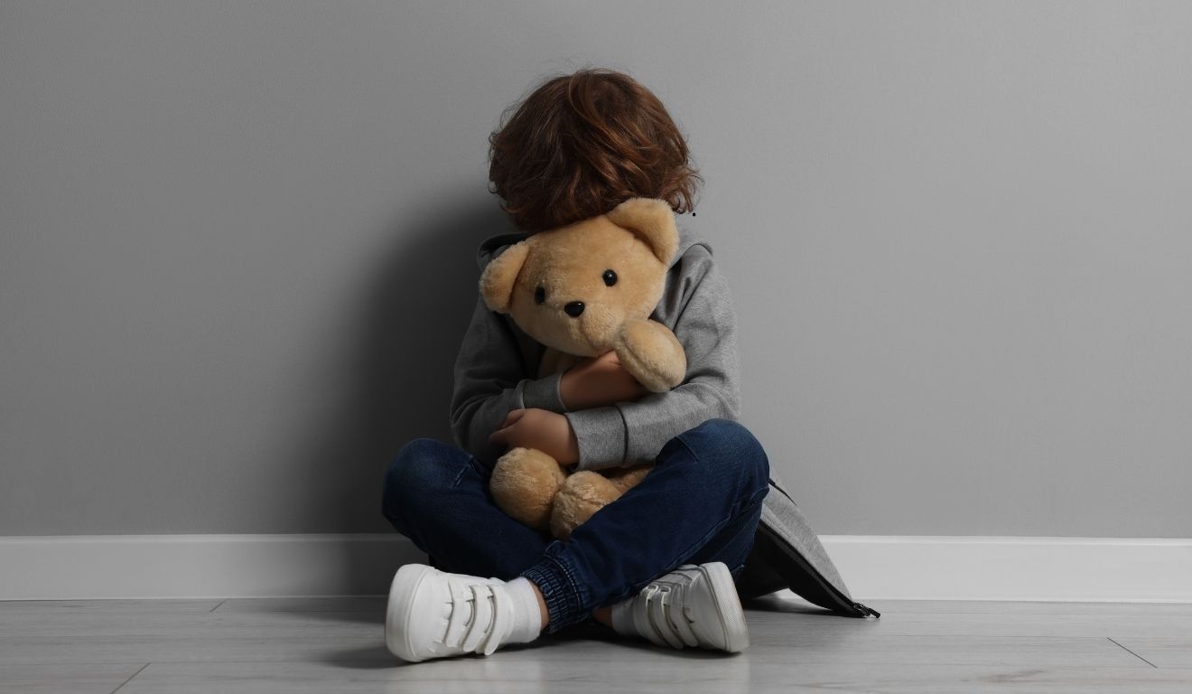 criança segurando urso de pelúcia