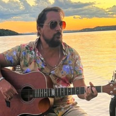 Mauri com um violão na beira de um rio