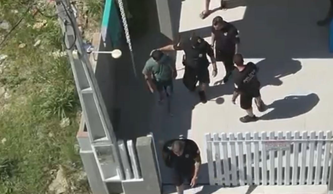 homem sendo preso após mulher se trancar no banheiro para fugir de agressões