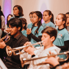 Crianças que compõe o Natal da Orquestra Infantojuvenil Alegro, com instumentos diversos.