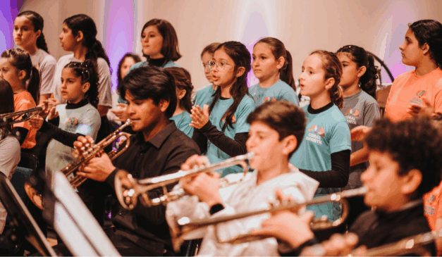 Crianças que compõe o Natal da Orquestra Infantojuvenil Alegro, com instumentos diversos.