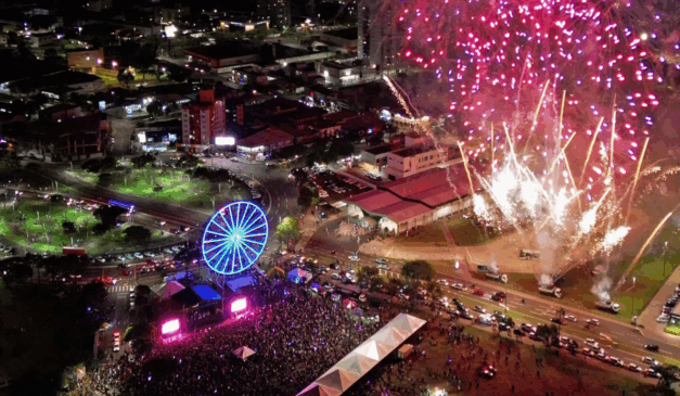 foto aérea da festa de comemoração do aniversário de casvavel, junto com o Natal de 2025, com público grande entorno de um palco e fogos de artifício.