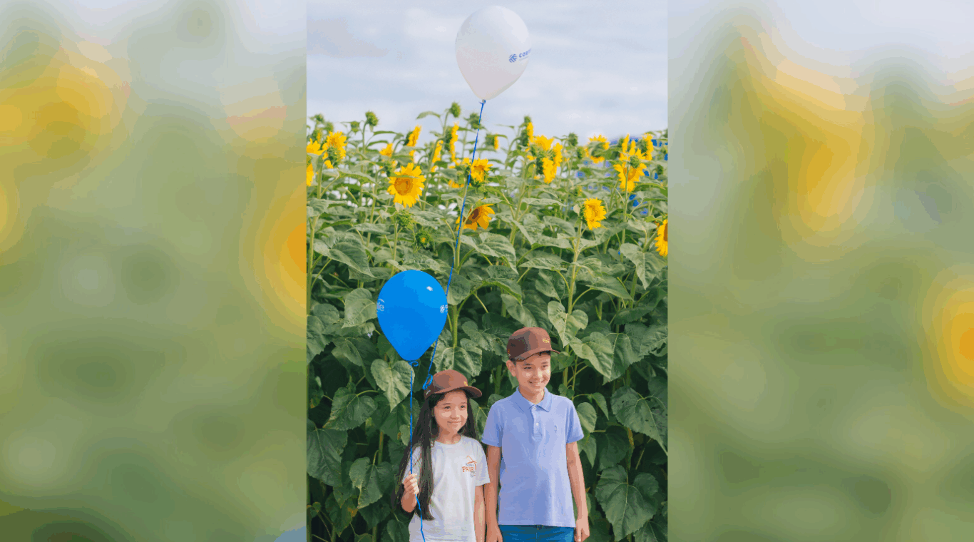 crianças em frente a uma plantação de girassol durante o dia de campo da c.vale