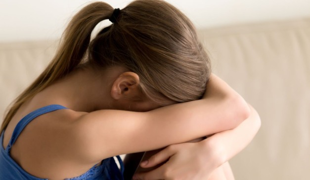 Imagem ilustrativa de criança com o rosto entre as mãos, em alusão ao caso da menina que denunciou em bilhete os abusos sexuais cometidos pelo padrasto