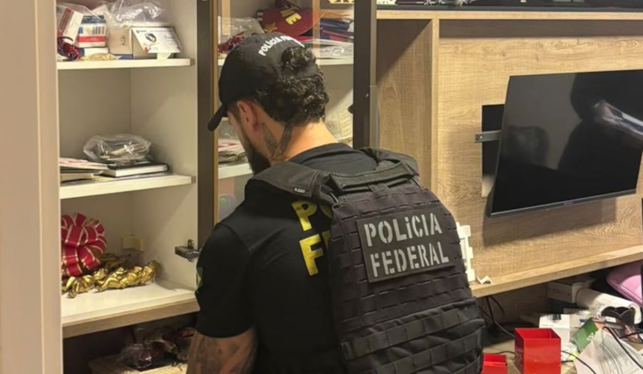 Agente da Polícia Federal em cumprimento de mandato de busca contra o deputado federal Eduardo Velloso