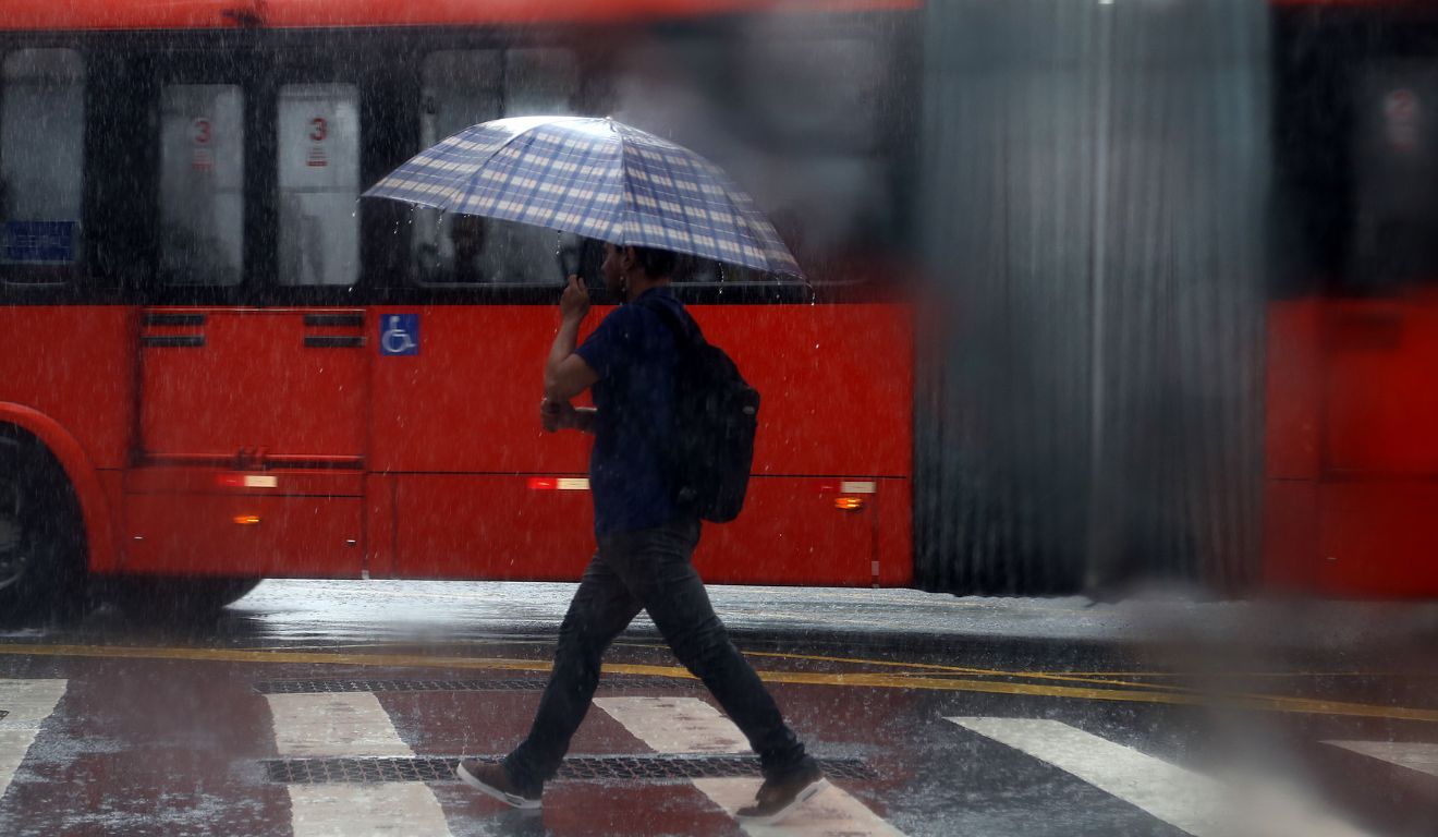 pessoa andando na chuva para ilustrar alerta laranja de tempestade no paraná