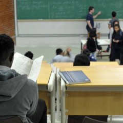 Estudante negro admitido por meio de cotas raciais assiste aula em universidade p&uacute;blica.