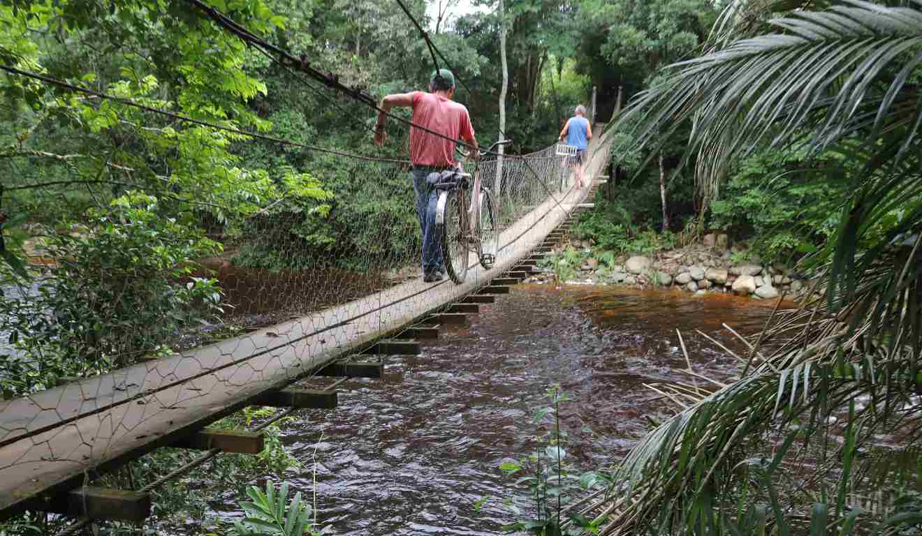 Pessoas andando em ponte por cima de cachoeira