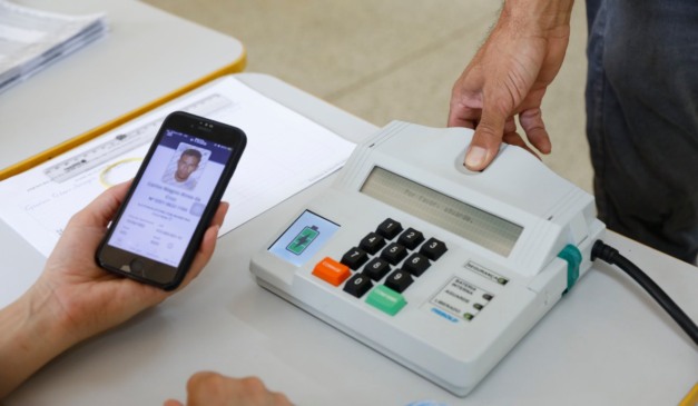 Mesário confere identidade de eleitor via aplicativo e biometria em seção eleitoral de Valparaíso, em Goiás, em 2024