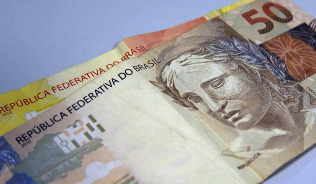 Cédulas de R$ 50 e de R$ 20 sobre a mesa
