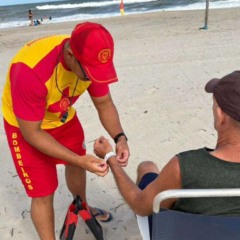 Idoso colocando pulseirinha de identifica&ccedil;&atilde;o no litoral do Paran&aacute;