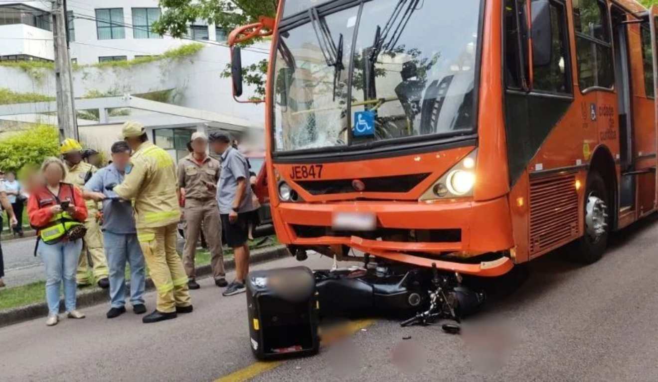 Motocicleta caída e presa em ônibus