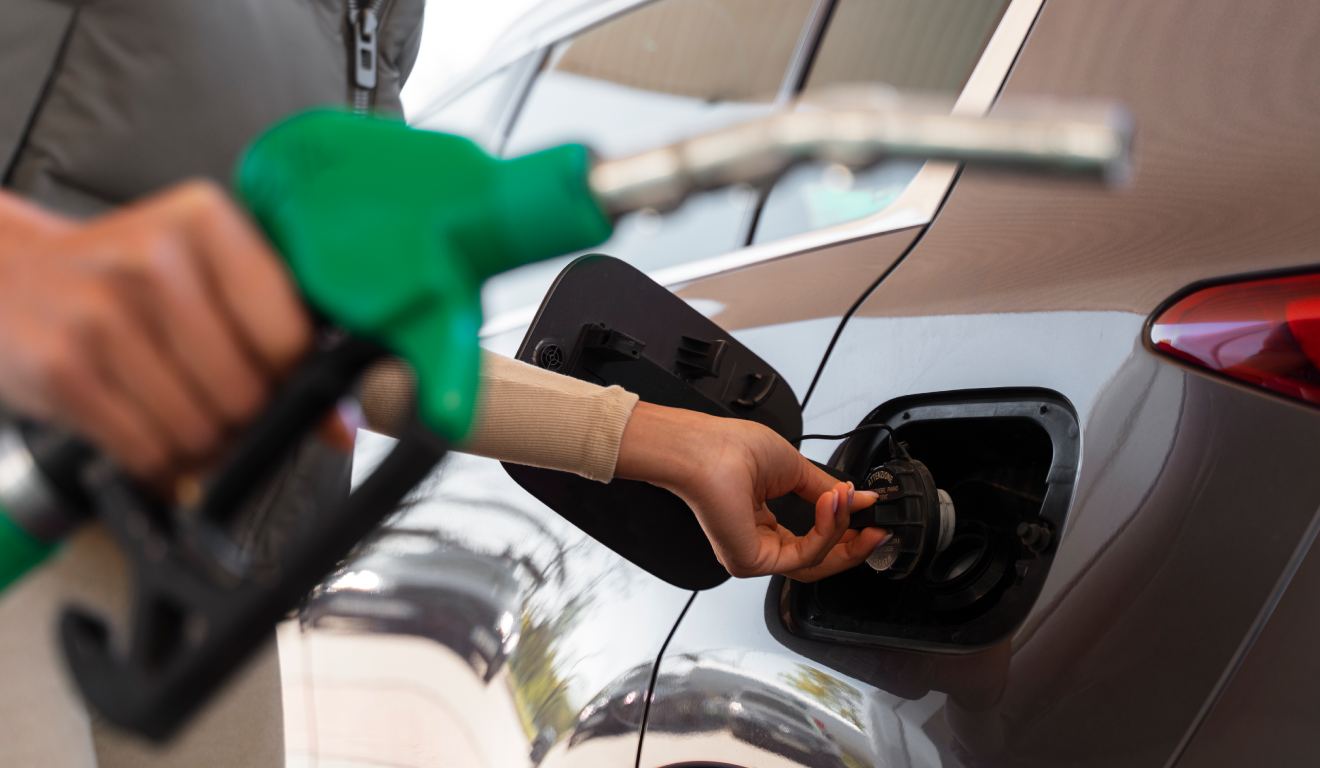 Homem enchendo o tanque de carro em posto de gasolina