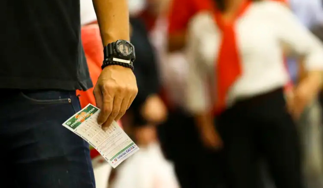Apostador com bilhete da Mega-Sena nas mãos