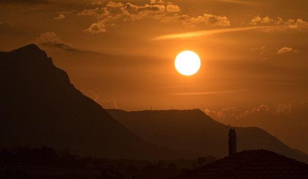 Sol ao fundo de uma montanha; El Niño pode aumentar valor da conta de luz e da inflação no Brasil