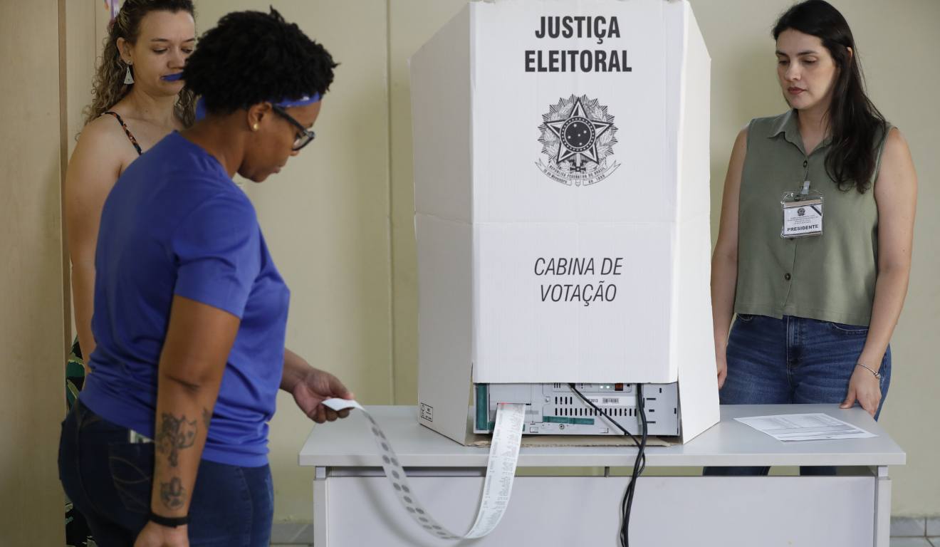 Mesários imprimem o boletim de urna ao fim das eleições de 2024 em Valparaíso de Goiás.