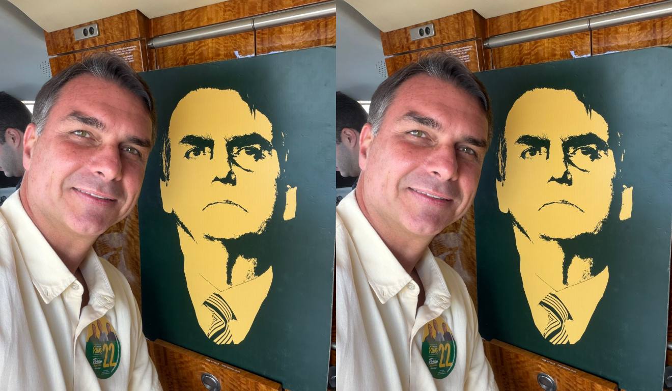 Flávio Bolsonaro posa ao lado de imagem do pai para agradecer resultado do 1º turno